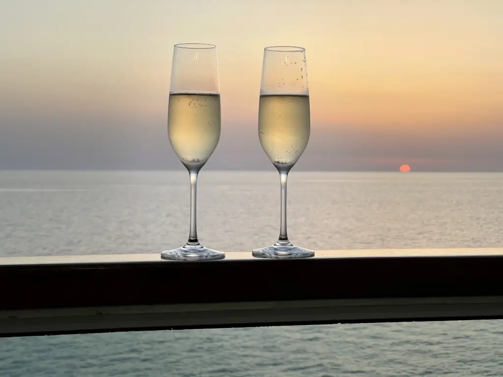 Gudrun Arnemann genießt ein Glas Champagner beim Sonnenuntergang auf den Balkon ihrer Suite.